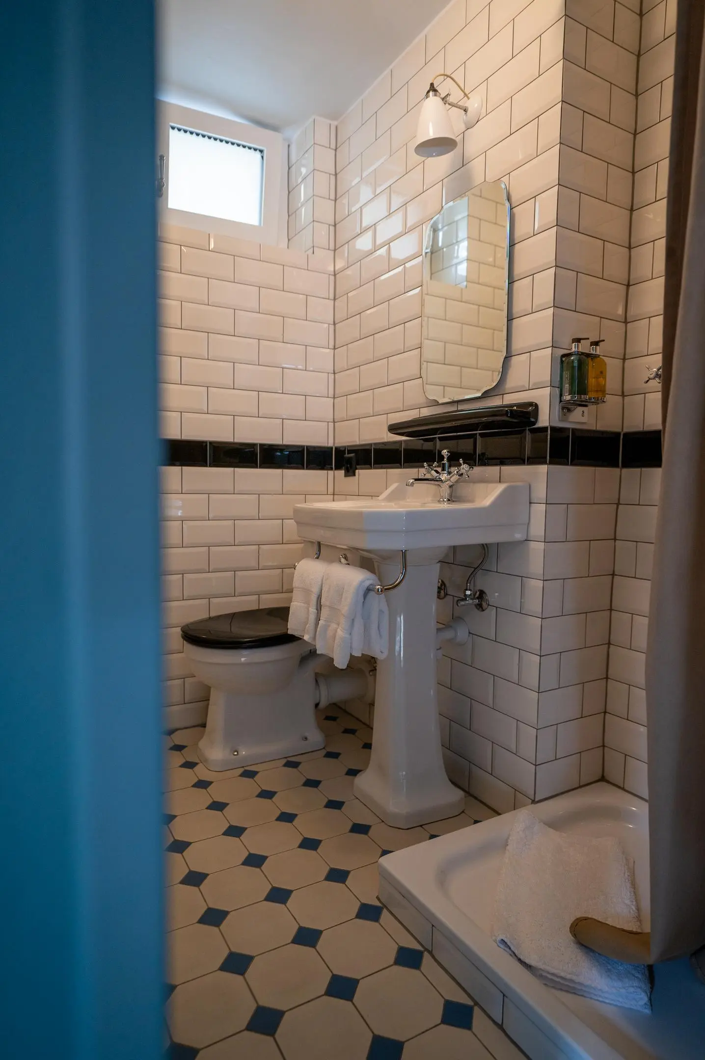 Hotel bathroom in English style with white Metro tiles and historic sanitary fixtures